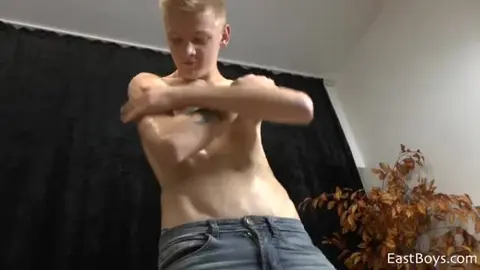 Blonder Twink mit geöltem Körper zeigt sich